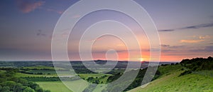 Dramatic and colourful mid-summer sunset over Beacon Hill from Old Winchester Hill in the South Downs National Park near Warnford