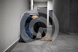 dramatic concept, Silhouette of a sad depressed woman sitting head in hands on the floor.