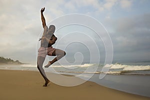 Dramatic contemporary dance choreographer doing ballet beach workout, young attractive and athletic afro black American man