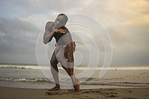 Dramatic contemporary dance choreographer doing ballet beach workout, young attractive and athletic afro black American man