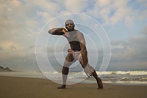 Dramatic contemporary dance choreographer doing ballet beach workout, young attractive and athletic afro black American man