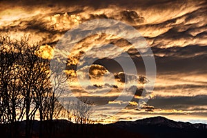 Dramatic Contrasting Clouds at Sunset With Mountains and Trees Winter Fall Sky photo