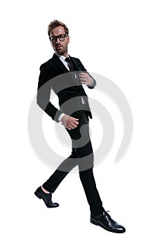 Dramatic cool businessman confidently adjusting black suit