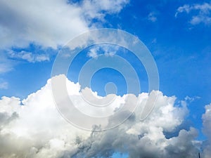 Dramatic cumulus clouds forming under a bright blue sky