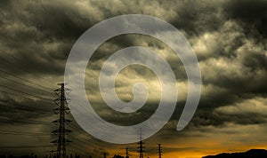 Dramatic dark sky and clouds and high voltage pole with electric cable. Cloudy sky background. Black sky before thunder storm.