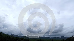 Dramatic dark stormy clouds over tropical summer rain-forest mountain peak