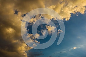 Dramatic darkclouds under blue sky with sunbeam