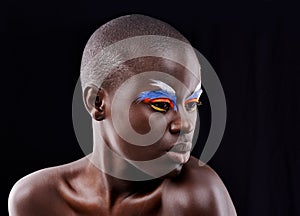 Dramatic eyes. Studio shot of a beautiful model posing with colorful eye makeup on a black background.