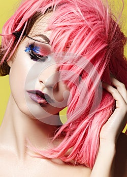 Dramatic Fashion Look young Woman in Pink Wig. Beautiful Model with bright Make-up. Carnival Accessories for Halloween