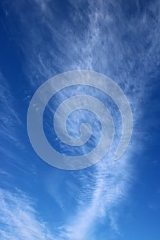 Dramatic feathery white clouds in blue sky