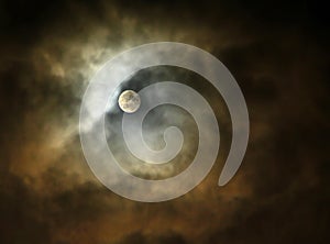 The dramatic Full Moon is between the night storm clouds.