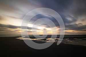 Dramatic golden sky with drifting clouds during sunset on Amrum island Germany in the North Sea