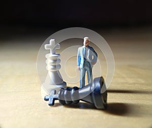 dramatic illustration for photo War or politic situation concept, 1 standing mini figure, help the king chess to win