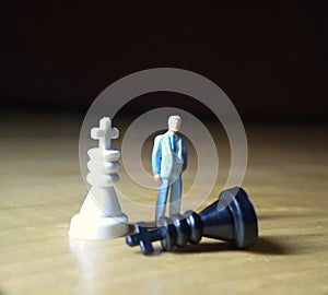 dramatic illustration for photo War or politic situation concept, 1 standing mini figure, help the king chess to win