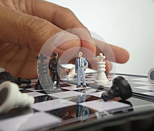 dramatic illustration for photo War or politic situation concept, 2 standing mini figure, man hand moving the other one,