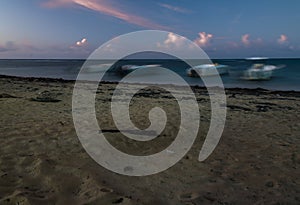 Dramatic image of a large tourist fishing boat anchored on the caribbean coast with the sun setting at night.