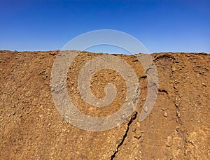 Dramatic image of a person standing on the ridge of the steep sided volcanic crater of Las Calderas volcano near Corralejo in Fuer
