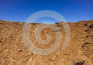 Dramatic image of a person standing on the ridge of the volcanic crater of Las Calderas Corralejo in Fuerteventura
