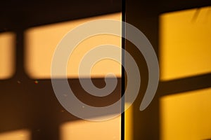 A dramatic interplay of light and shadow: sunbeams stream through a window, casting harsh geometric shadows on a