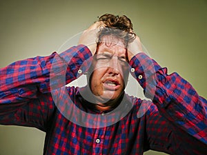 Dramatic isolated portrait of young desperate and stressed man suffering anxiety crisis and depression problem screaming