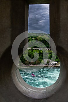 Dramatic Keyhole view of Rhein Rhine water fall in switzerland, background has green forest and dramatic cloudy sky