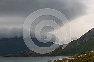 Dramatic landscape of coastal scene with thick clouds on a mountain.