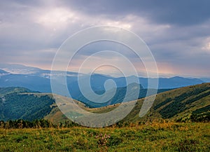 Sun Rays Breaking Through Clouds Over Mountain Valley