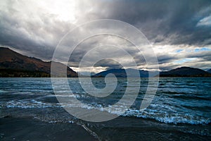 Dramatic landscape of tumultuous lake Wakatipu with hills of Central Otago, New Zealand