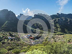 Dramatic lush green picturesque valley with old village Los Carrizales . Landscape with sharp rock formation, hills and