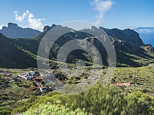 Dramatic lush green picturesque valley with old village Los Carrizales . Landscape with sharp rock formation, hills and