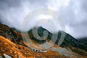 Dramatic Mountain Landscape Rugged Slopes, Golden Grass, and Low Clouds