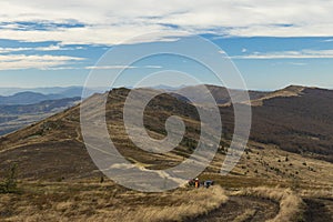 Dramatic mountain ridge moody autumn season time soft focus hiking group of people on touristic walking route dirt trail lonely