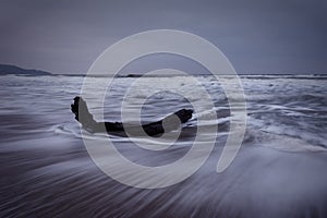 Dramatic nature background - big waves and dark rock in stormy sea, stormy weather. Dramatic scene.