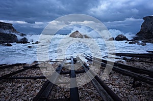 Dramatic nature background - big waves and dark rock in stormy sea, stormy weather. Dramatic scene. Contrasting colors.