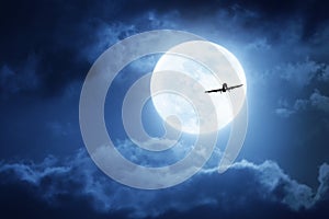 Dramatic Nighttime Sky With Large Full Blue Moon and Commercial Aircraft