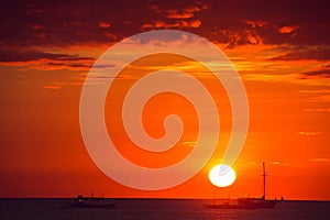 Dramatic orange sea sunset with boats. Summer time. Travel to Philippines. Luxury tropical vacation. Boracay paradise island.