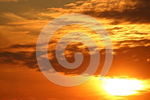 Dramatic orange, yellow clouds and sun, sunset