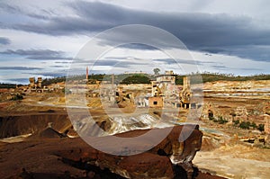 Dramatic overcast sky over ruined sulfur extraction ovens and chimneys