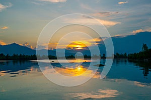 Dramatic panorama evening sky and clouds over mountain and lake at sunset photo