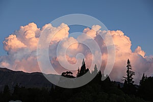 Dramatic pink clouds over a silhouetted landscape