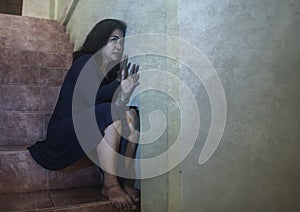 Dramatic portrait of 50s woman depressed on staircase - mature lady sad and lonely suffering depression and middle age crisis