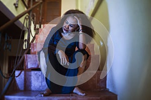 Dramatic portrait of 50s woman depressed on staircase - mature lady sad and lonely suffering depression and middle age crisis