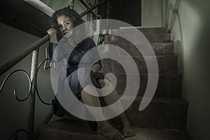 Dramatic portrait of 50s woman depressed on staircase - mature lady sad and lonely suffering depression and middle age crisis