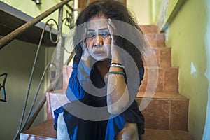 Dramatic portrait of 50s woman depressed on staircase - mature lady sad and lonely suffering depression and middle age crisis