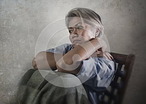 Dramatic portrait of attractive sad and depressed mature woman with grey hair in pain suffering mental disorder or depression