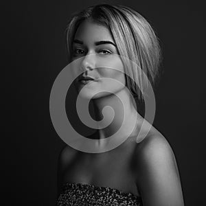 Dramatic portrait of a girl theme: portrait of a beautiful girl on a dark background in studio