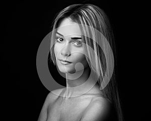 Dramatic portrait of a girl theme: portrait of a beautiful girl on a dark background in studio