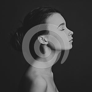 Dramatic portrait of a girl theme: portrait of a beautiful girl on a dark background in studio