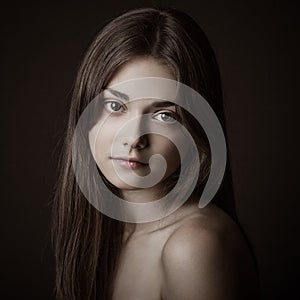 Dramatic portrait of a girl theme: portrait of a beautiful girl on a dark background in studio