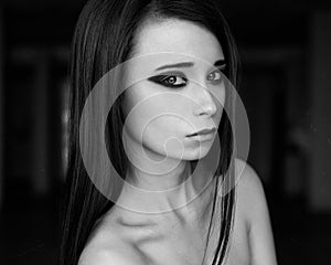 Dramatic portrait of a girl theme: portrait of a beautiful girl on a dark background in studio